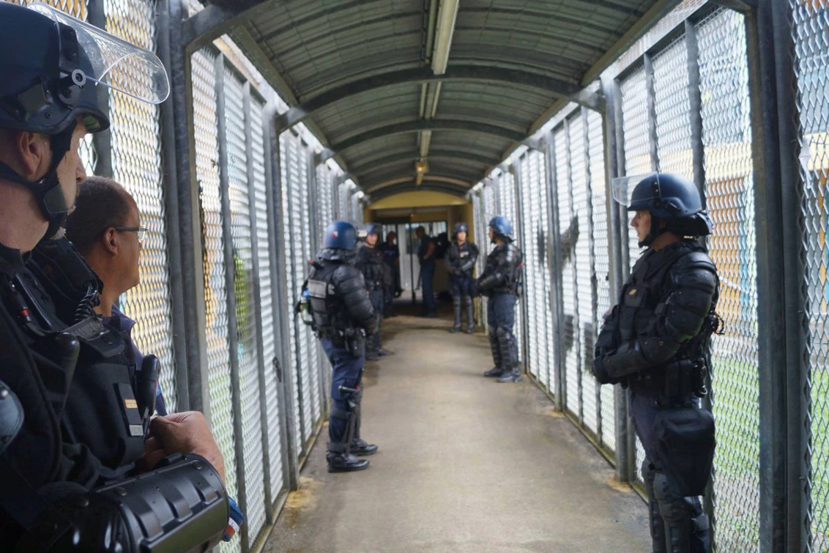 Policiers et forces de l'ordre dans les couloirs de la prison de Baie-Mahault pour une fouille