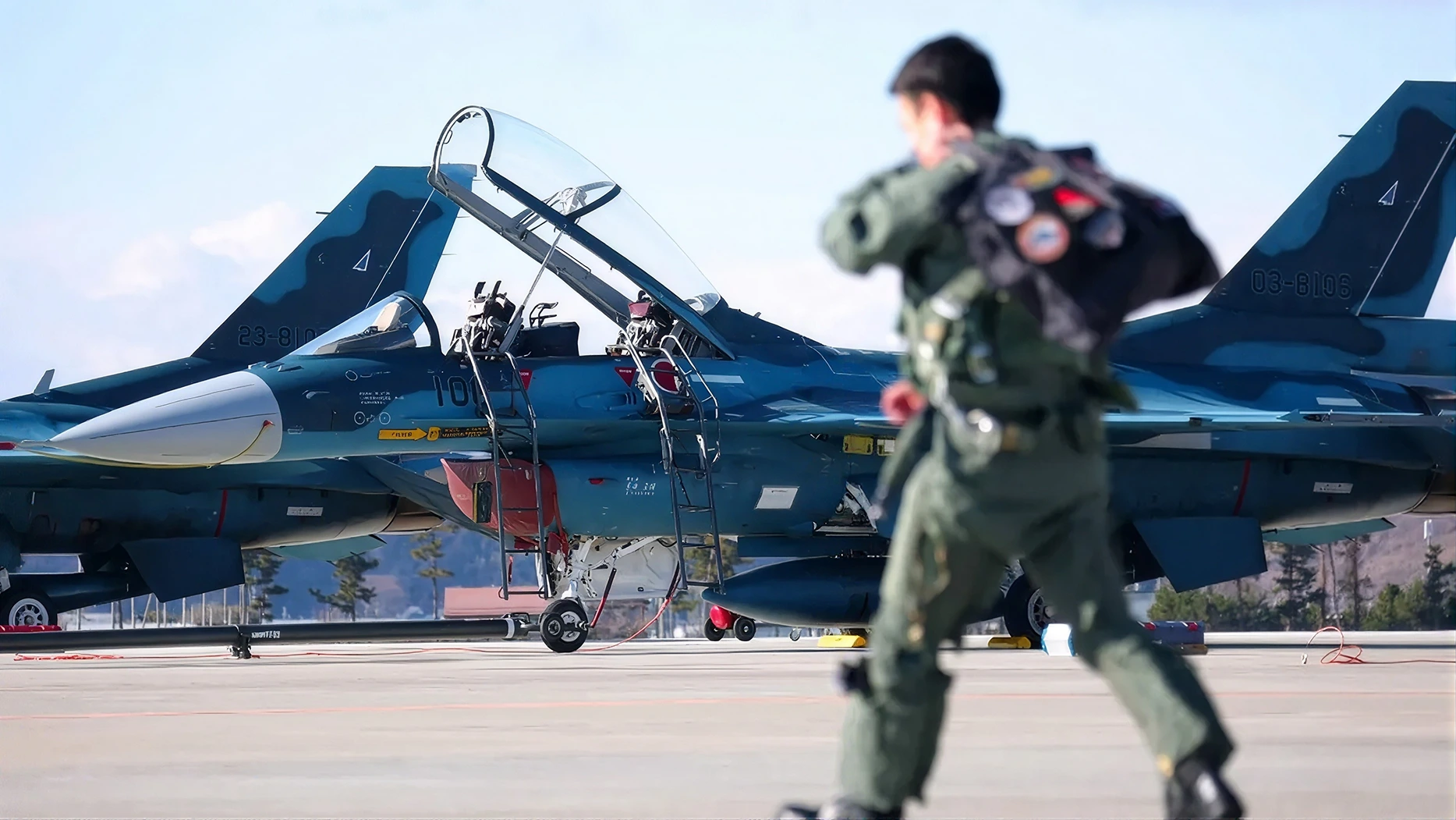 Un pilote des forces aériennes d’autodéfense japonaises court vers ses chasseurs sur une base aérienne